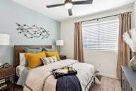 Two-Bedroom Luxury Apartments in Henderson, NV - Parq on Boulder - Bedroom With Full-Size Bed, Wood-Style Flooring, Ceiling Fan, And Curtains.