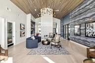 A modern living room with a large rug and a chandelier.