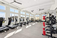A spacious gym with treadmills, elliptical machines, and other exercise equipment.