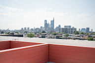 the view of the city from the rooftop terrace of a building with a bench