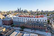 an aerial view of a building with a city in the background