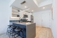 A kitchen with a bar stool and a counter.