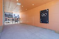 A sign for GIO is on the wall in a parking garage.