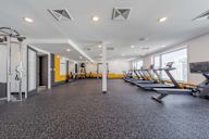 A gym with treadmills, weights, and exercise equipment.