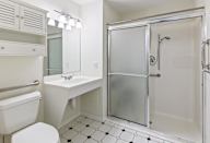 A white bathroom with a walk in shower.