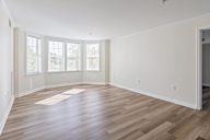 A room with wooden flooring and white walls.