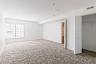 A room with a carpeted floor and a doorway leading to another room.