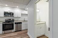 A kitchen with white cabinets and stainless steel appliances.