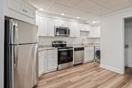 A kitchen with white cabinets and stainless steel appliances.