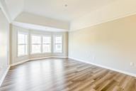 A room with wooden flooring and a large window.