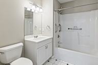 A white bathroom with a toilet, sink, and bathtub.
