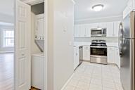 A kitchen with white appliances and cabinets.