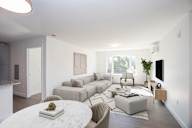 A living room with a white marble table and a grey couch.