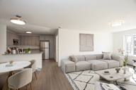 A modern living room with a grey sofa and a white coffee table.