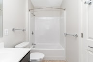 A white bathroom with a toilet, sink, and bathtub.