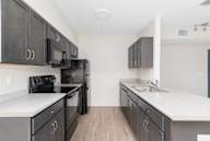 A kitchen with black cabinets and white countertops.