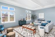 A living room with a white couch, a wooden coffee table, and a rug with a geometric pattern.