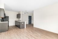 A kitchen with a refrigerator, microwave, and oven.