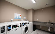 A laundry room with washing machines and a sink at Hudson Heights Apartments, Mechanicville, NY