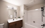 A bathroom with a white sink and a white bathtub at Hudson Heights Apartments, Mechanicville, NY