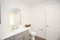 A white toilet sits in a bathroom next to a white door.