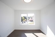A white room with a window and a picture on the wall.
