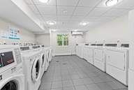 A row of white front load washing machines in a laundromat.