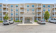 A large apartment complex with a parking lot in front.