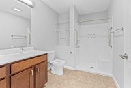 A white bathroom with a toilet, sink, and shower.