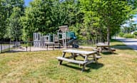 A playground with a picnic table and a fence in the foreground.