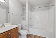 A white bathroom with a toilet, sink, and bathtub.