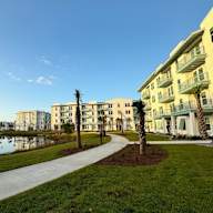 a sidewalk leading to a building with palm trees in front of it at Saltaire Apartment Homes in FL 32459