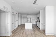 A white kitchen with a wooden floor and a white island in the middle at Saltaire Apartment Homes in Santa Rosa Beach, FL