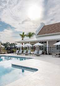 A pool with a white building behind it.