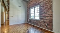 an empty room with a brick wall and a window