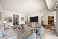 A modern living room with a white sofa, a coffee table, and a television.