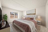 A bedroom with a large bed and a window overlooking a snowy landscape.