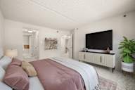 A modern bedroom with a large bed and a flat screen TV.