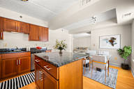 A kitchen with a black granite countertop and wooden cabinets.