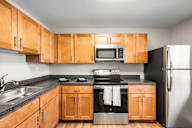 A kitchen with wooden cabinets and black appliances.