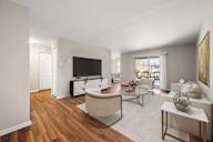 A living room with a white couch, a coffee table, and a television.