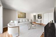 A modern living room with a white sofa and a glass coffee table.