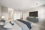 A bedroom with a large bed and a television on a cabinet.