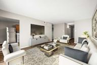 A modern living room with a white sofa, a coffee table, and a glass door cabinet.