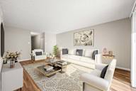 A living room with a white sofa, a coffee table, and a painting on the wall.