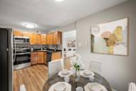 A modern kitchen with a dining table set for four.