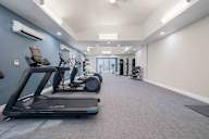 A spacious gym with treadmills and elliptical machines.