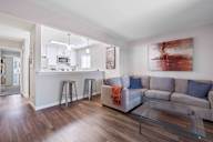 A modern living room with a grey couch and a glass coffee table.