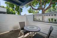 A patio with a table and chairs under a tree.