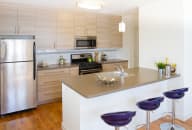 a kitchen with a center island next to a stove top oven